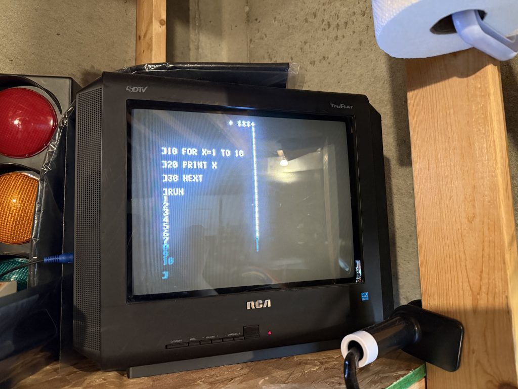 a CRT television display BASIC code being run. there are random characters on the screen as well, indicating a display error
