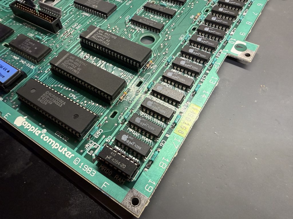 an Apple //c motherboard with a new ram chip in a socket at the MRD0 RAM position