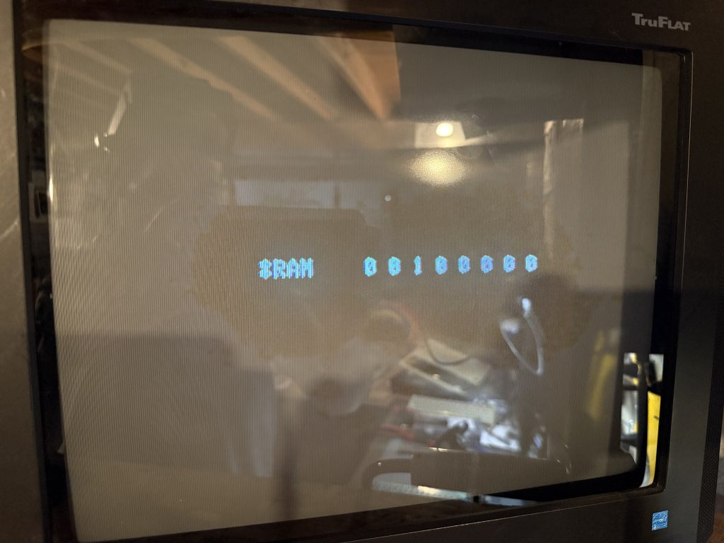 a CRT screen showing the text "*RAM 0 0 1 0 0 0 0 0"