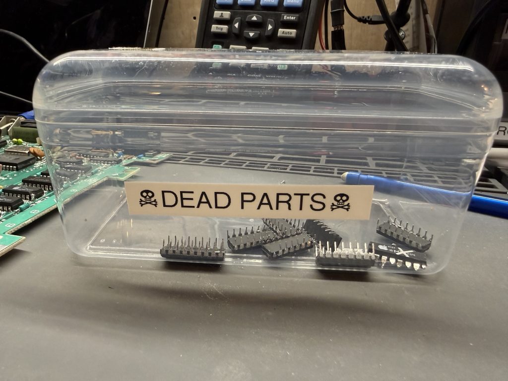 a plastic tub labeled "Dead Parts" with chips inside of it