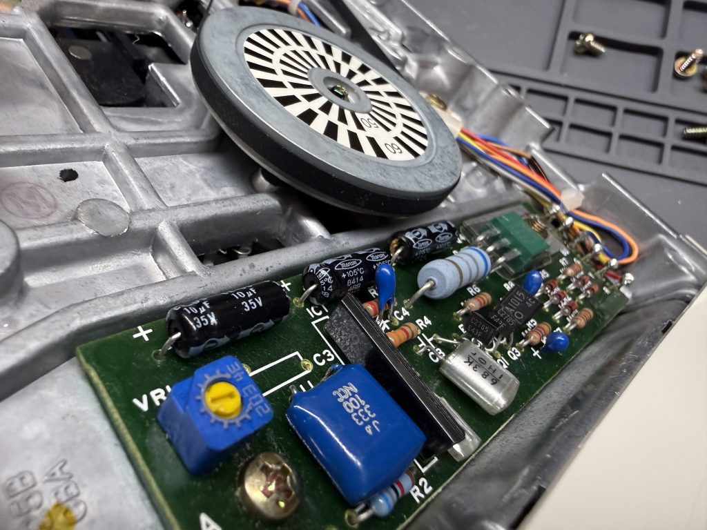 a closeup of an Apple //c floppy drive showing leaking capacitors