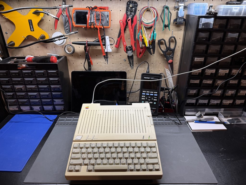an Apple //c sitting on a workbench