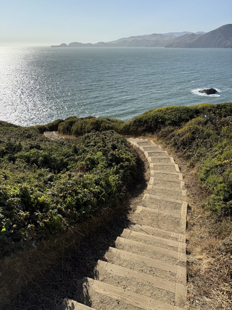 stairs wind down the side of a hill to the ocean
