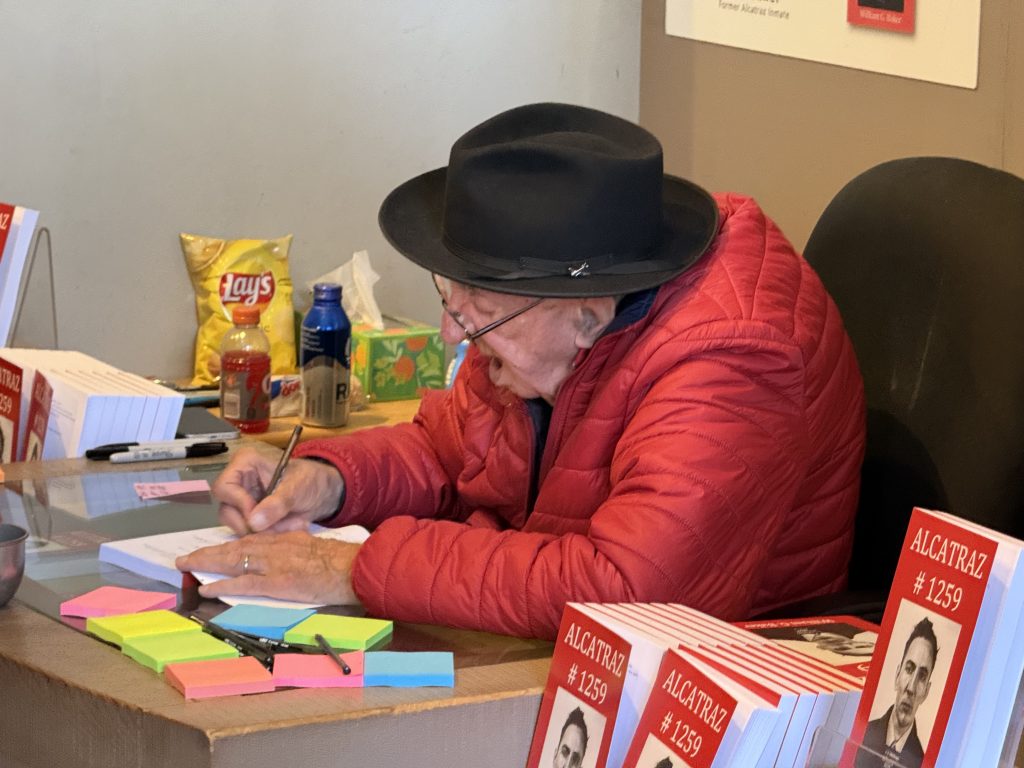 an old man signing a book