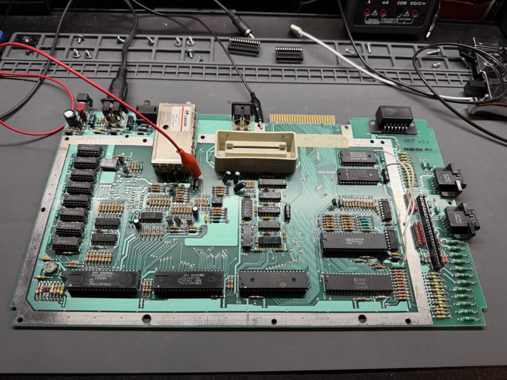 a green pcb sitting on a workbench. there are red and black wires connected to it
